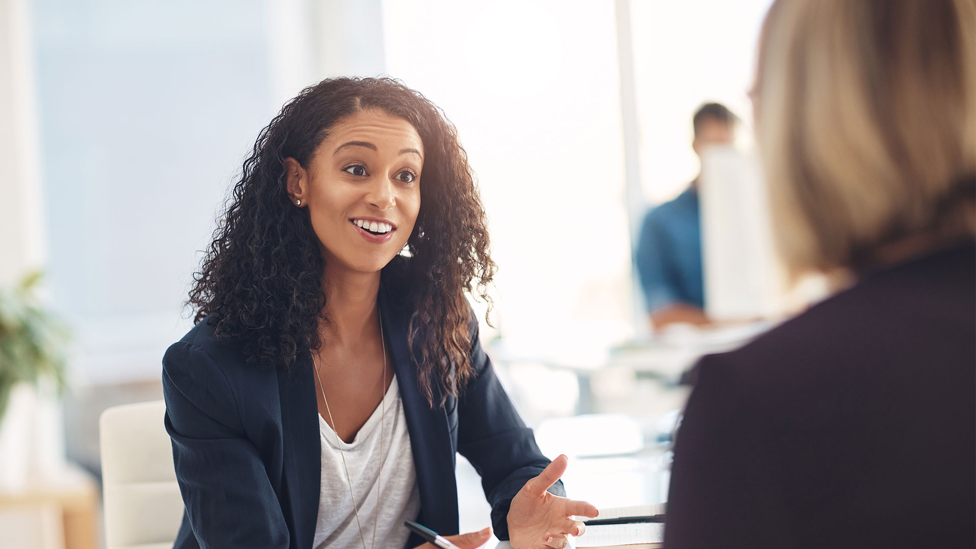 Effective Performance Management Strategies: A Young Female Professional Smiles at Her Colleague.